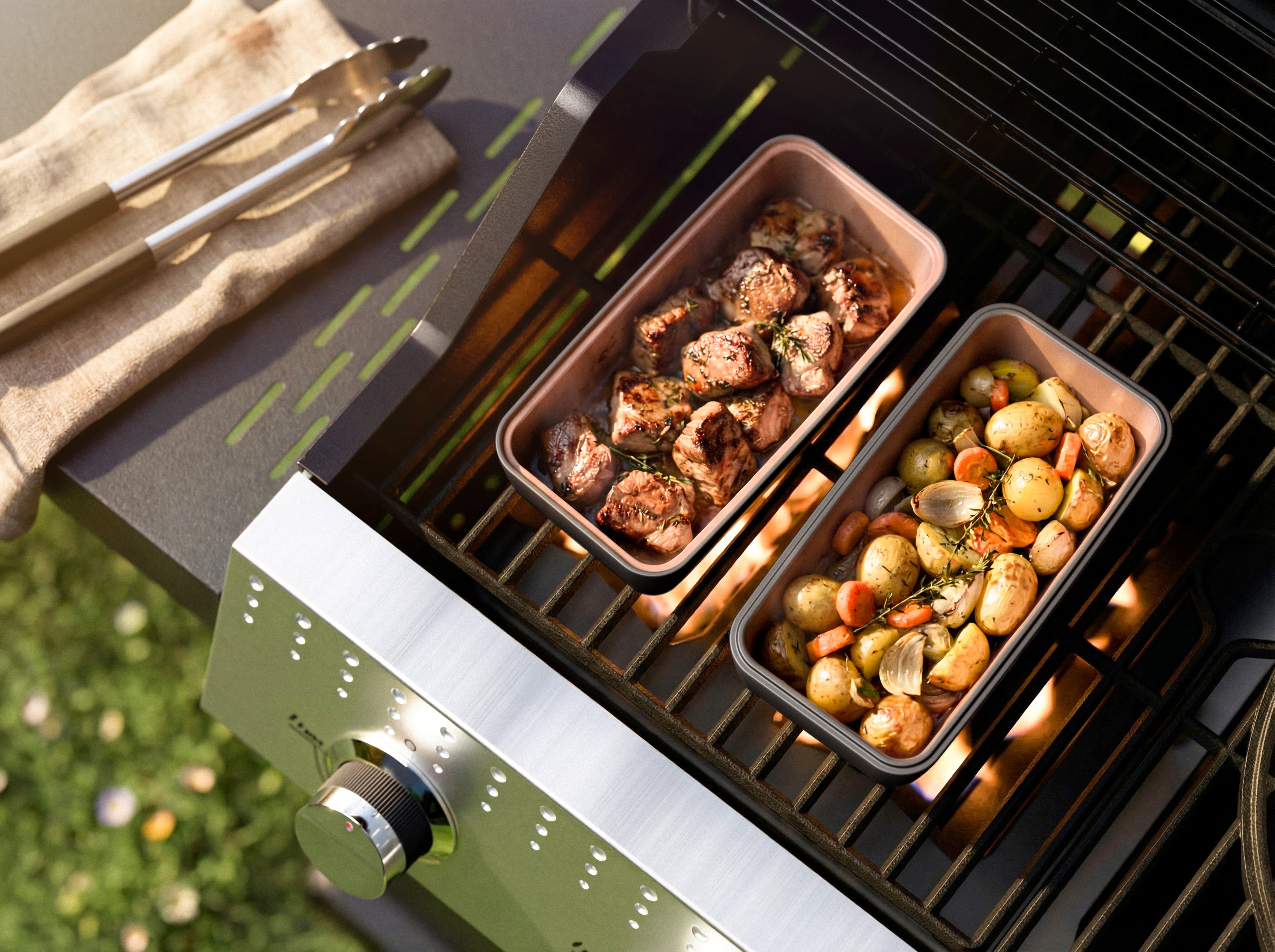 Zwei myromy Brick BBQ (Backstein) aus Keramik auf einem Gasgrill, gefüllt mit gebratenem Fleisch sowie Kartoffeln, Möhren und Zwiebeln