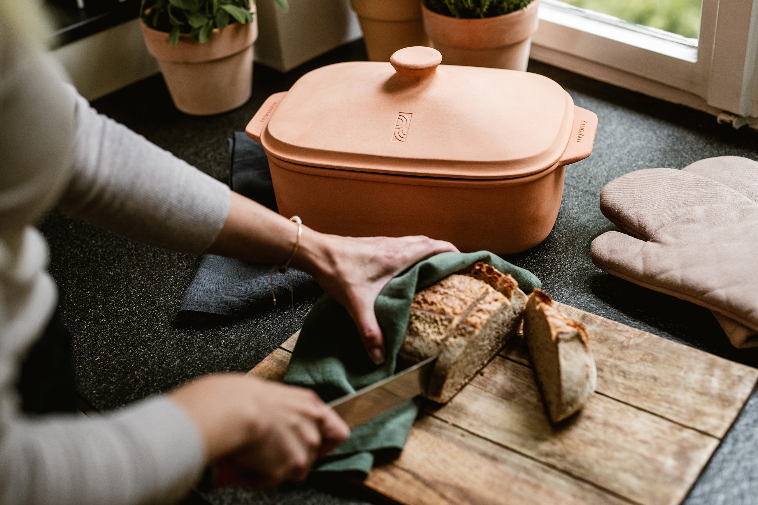 Brotkasten aus Ton – der myromy Brot-Frische-Topf ist der ideale Lagerort für Brot und Gemüse für maximale Frische – hier auf der Anrichte einer Küchen in Szene gesetzt bei Tageslicht