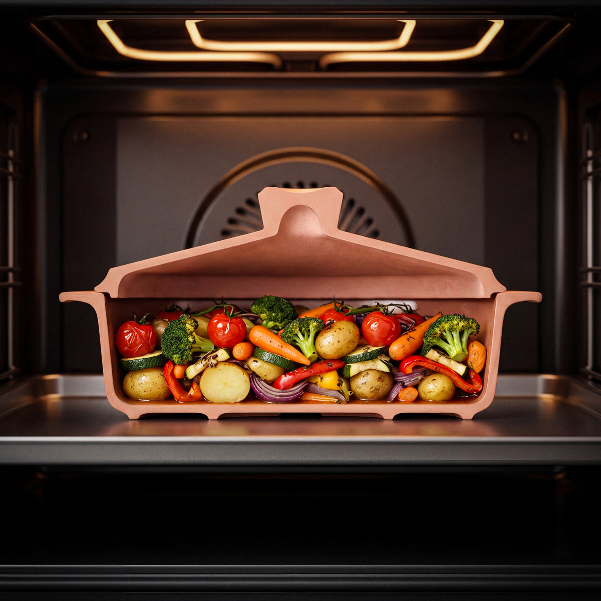 Querschnitt des myromy Multi-Bräters und der Brotbackform 3,5 L Medium mit Kartoffeln, Brokkoli, Paprika und Tomaten im Backofen
