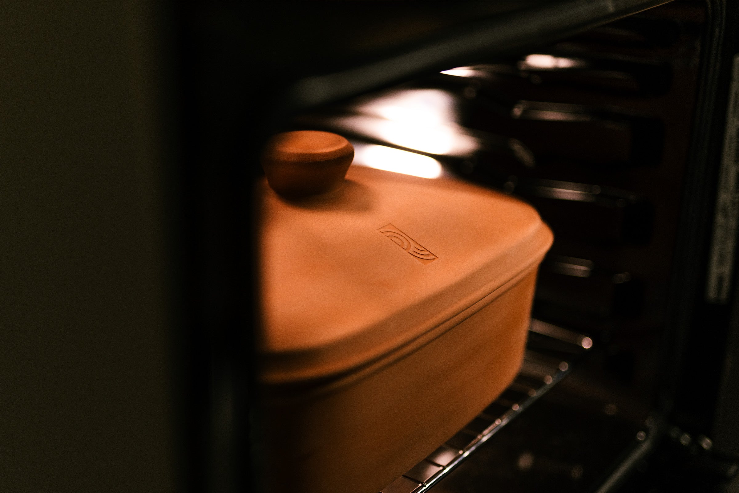 Geschlossener myromy Multi-Bräter in der Signature Edition als Keramik-Brotbackform und Keramik-Topf auf dem Rost im Backofen