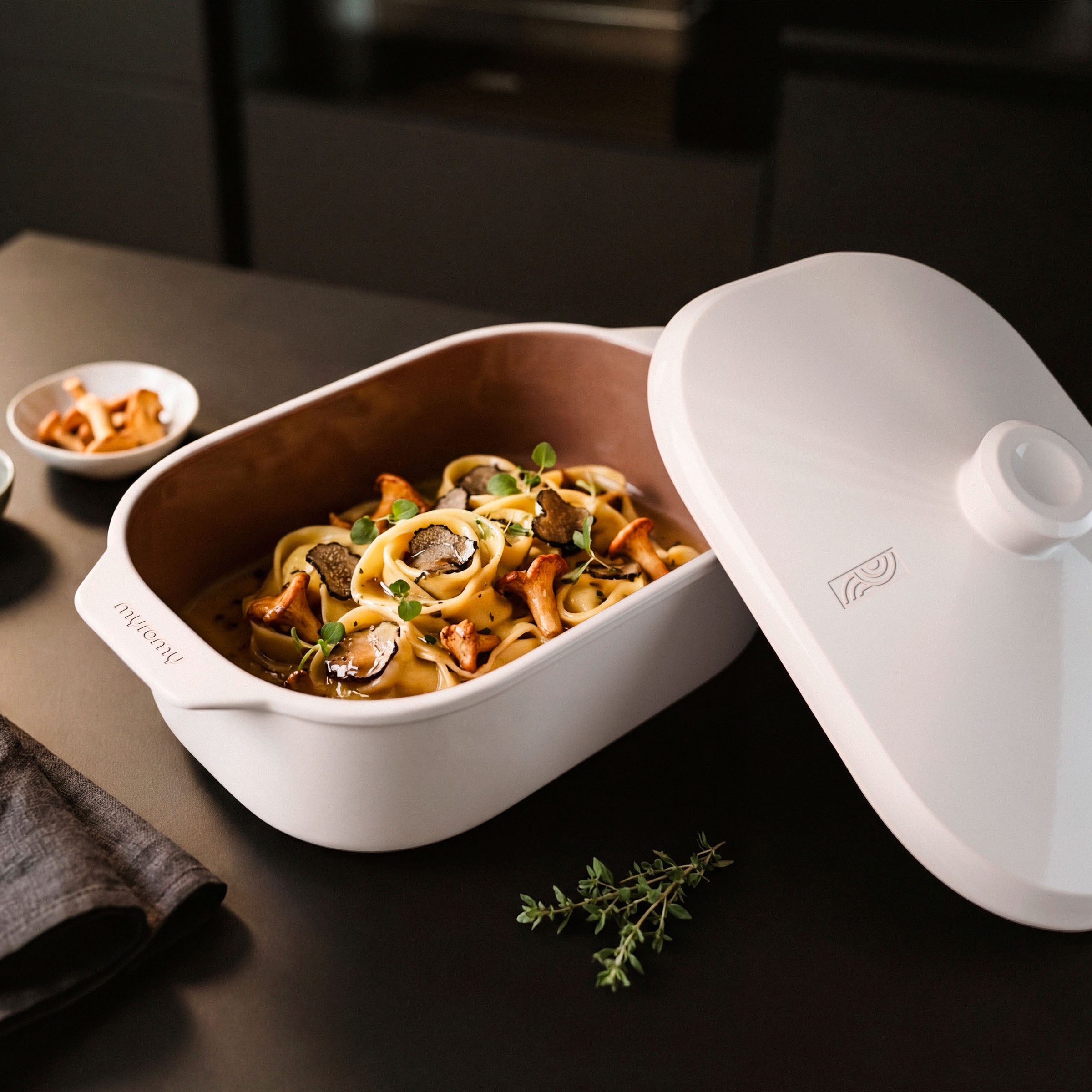 Pasta mit Pilzen und Trüffel im weißen myromy Multi-Bräter als Keramik-Topf, daneben der abgenommene Deckel
