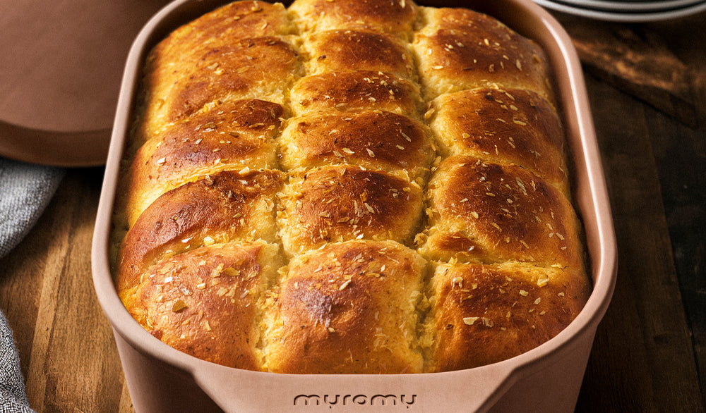 Goldbraun gebackener Hefezopf in einer myromy Brotbackform aus Keramik, frisch aus dem Backofen