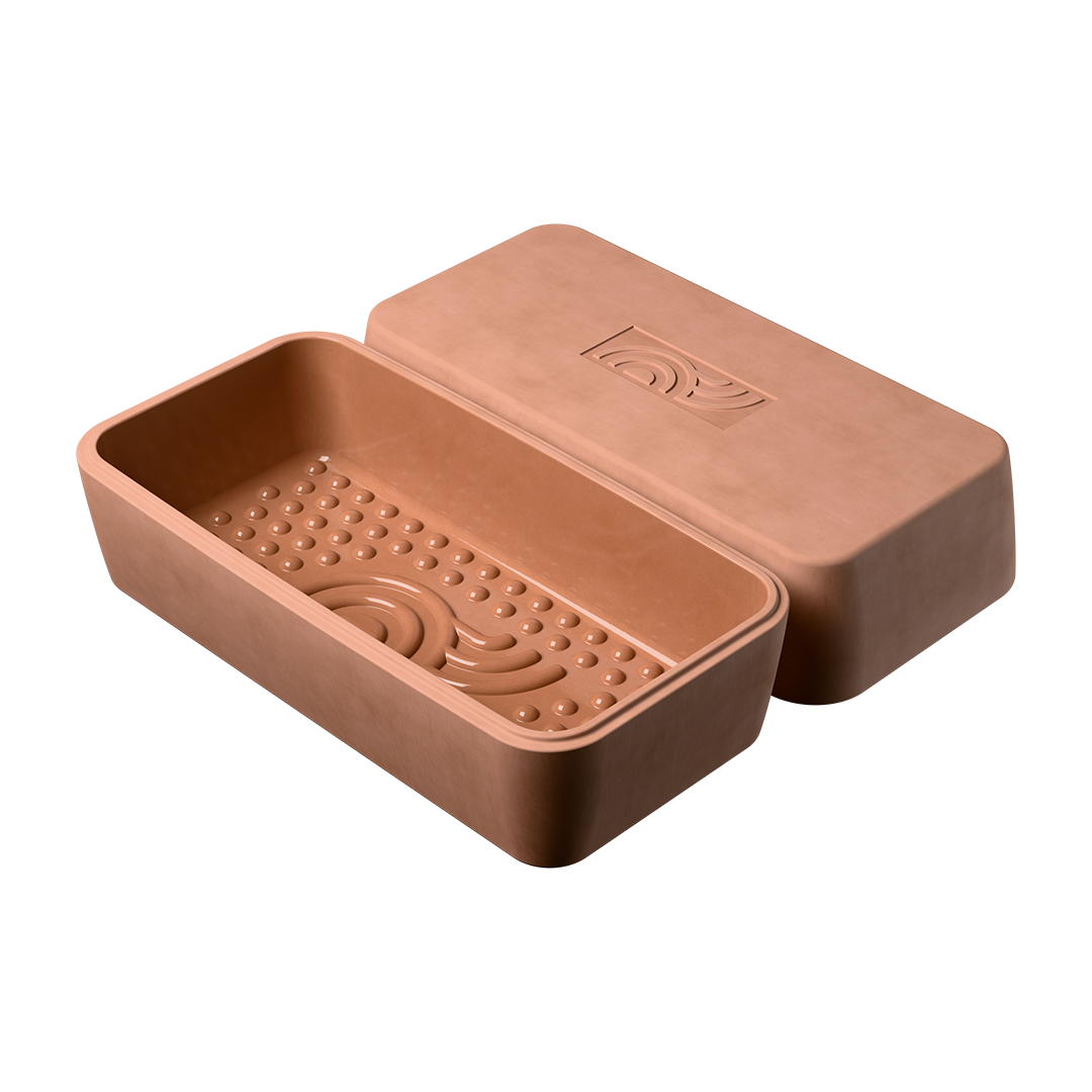 Der myromy BBQ Brick als Backstein oder kleiner Bräter, geöffnet mit sichtbaren Aromanoppen und Deckel