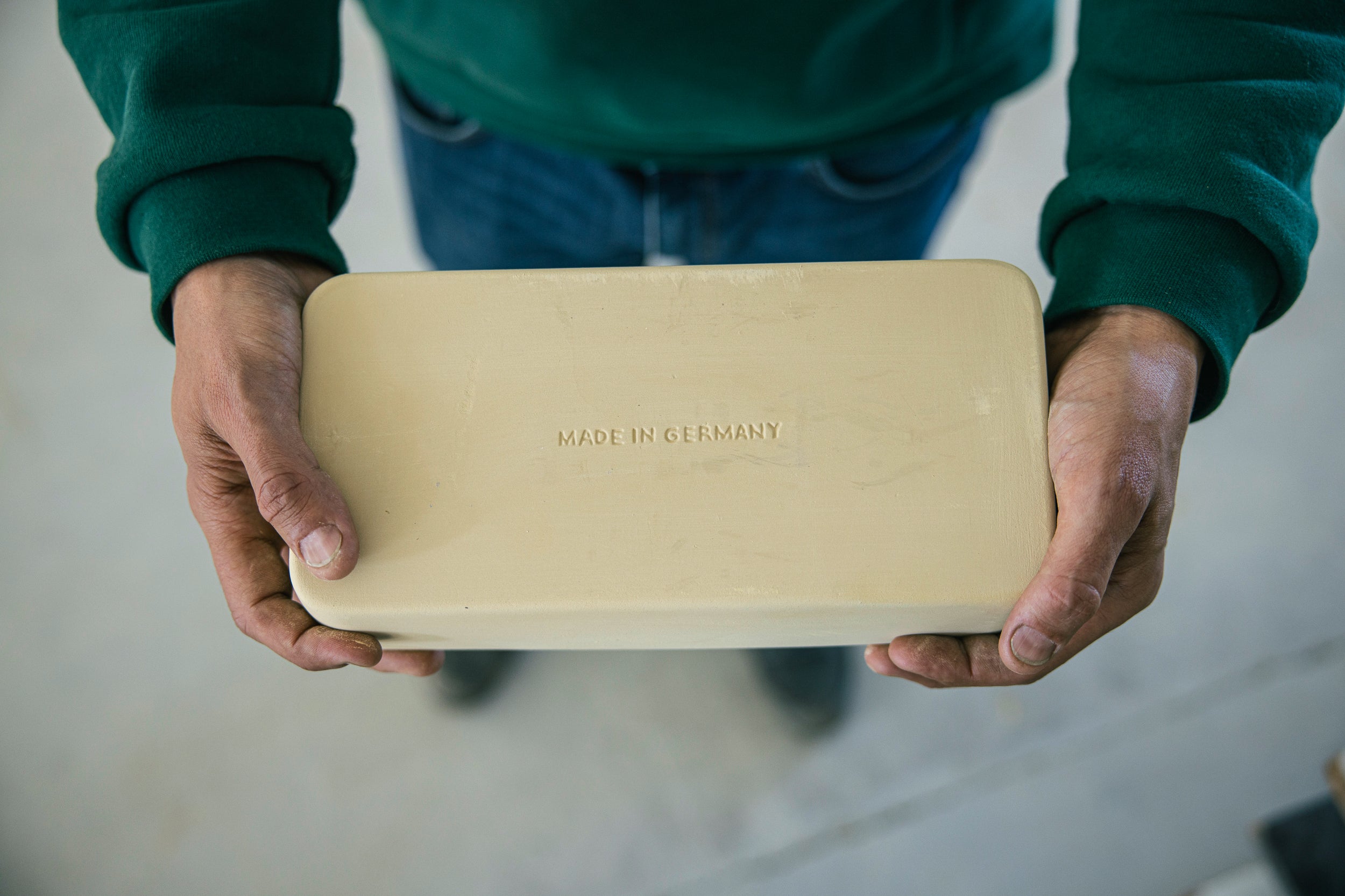 myromy keramiken stehen für deutsche Wertarbeit und den Glaube an den Standort Deutschland: hier ein Mini-bräter mit dem Emblem "Made in Germany" auf der Unterseite, gehalten von einem Mitarbeiter