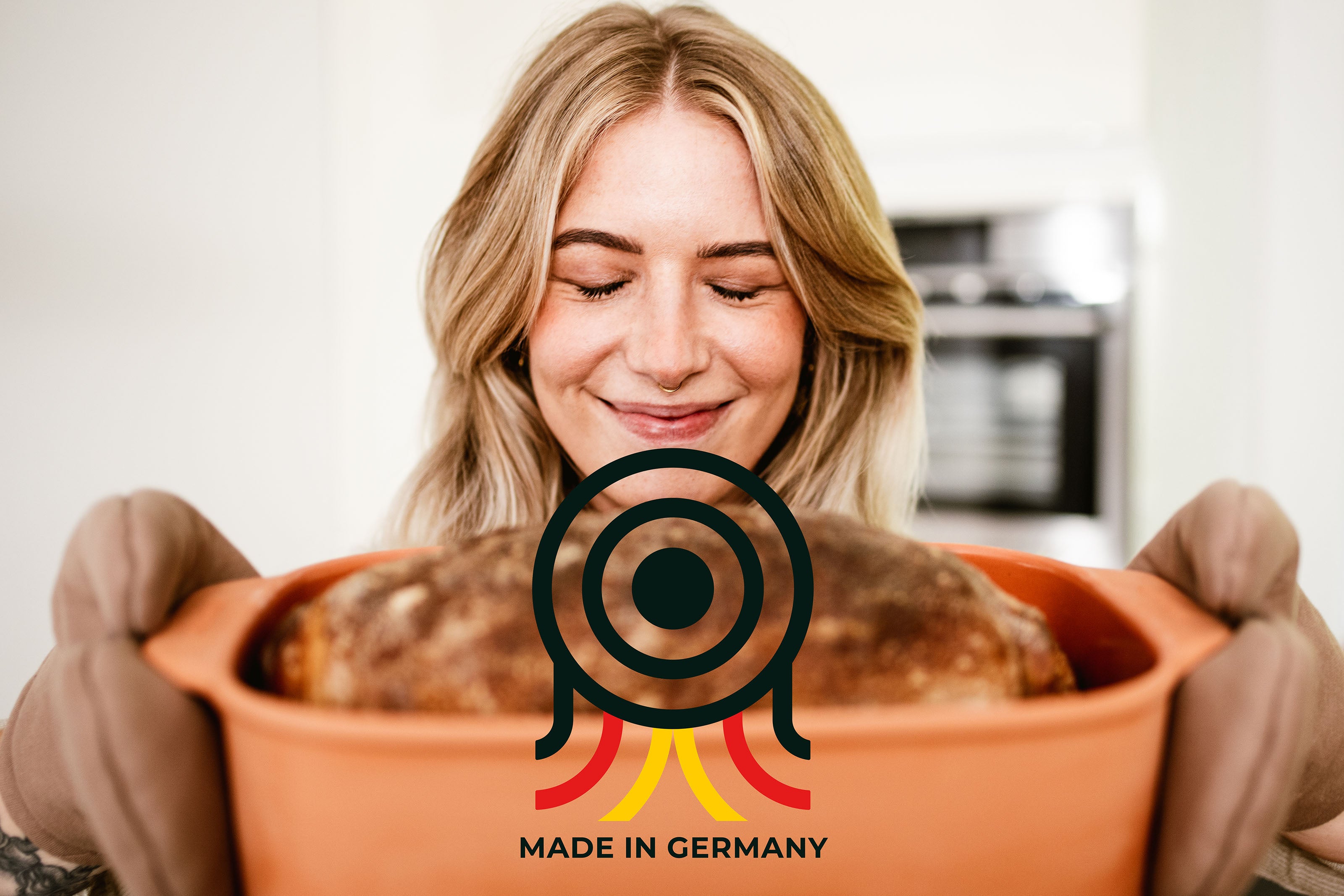 myromy Keramik-Bräter als Brotbacktopf mit frisch gebackenem Brot, getragen mit Ofenhandschuhen und Made-in-Germany-Kennzeichnung