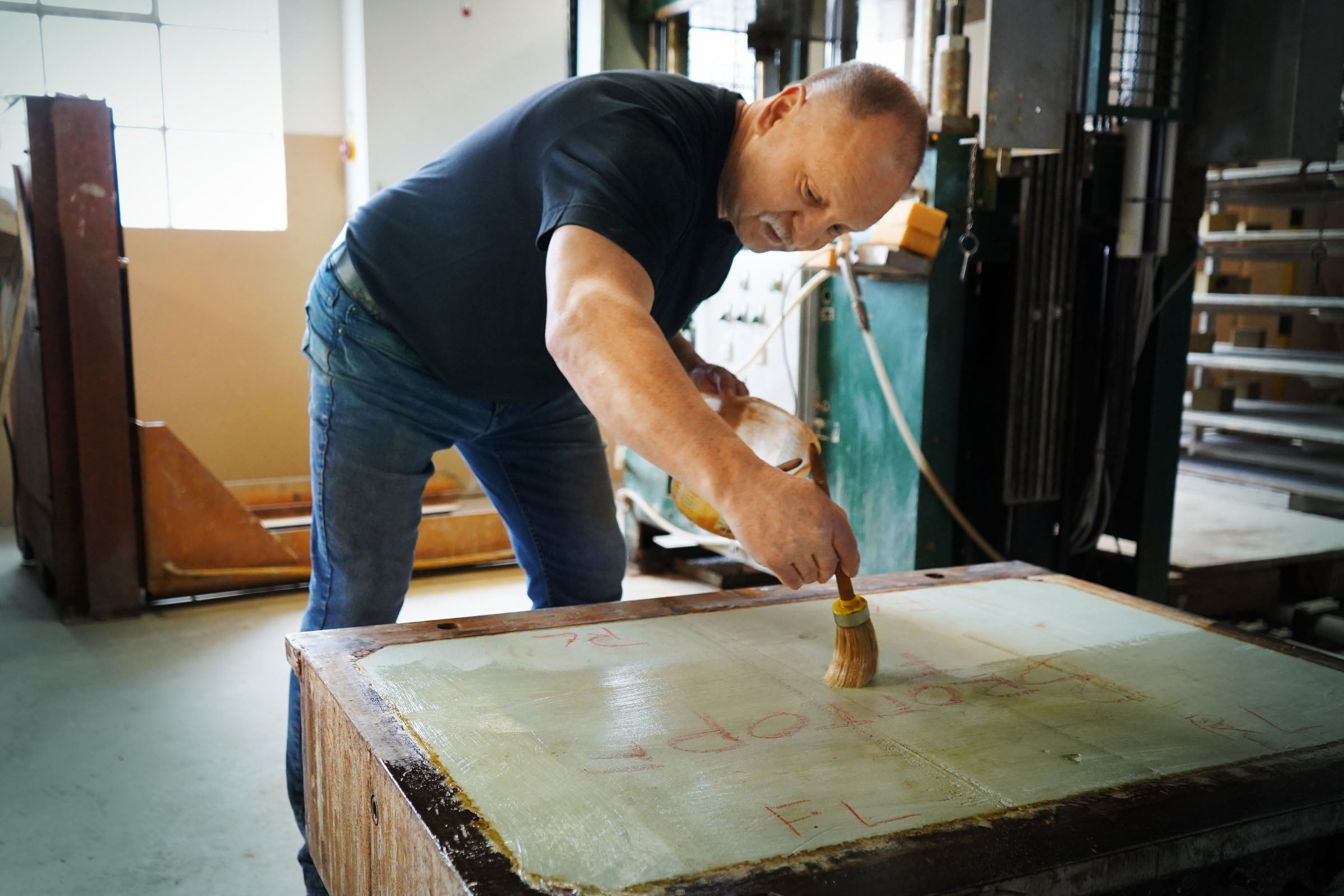 Mitarbeiter bereitet in der myromy Keramik-Manufaktur eine Produktionsform von Hand mit einem Pinsel vor