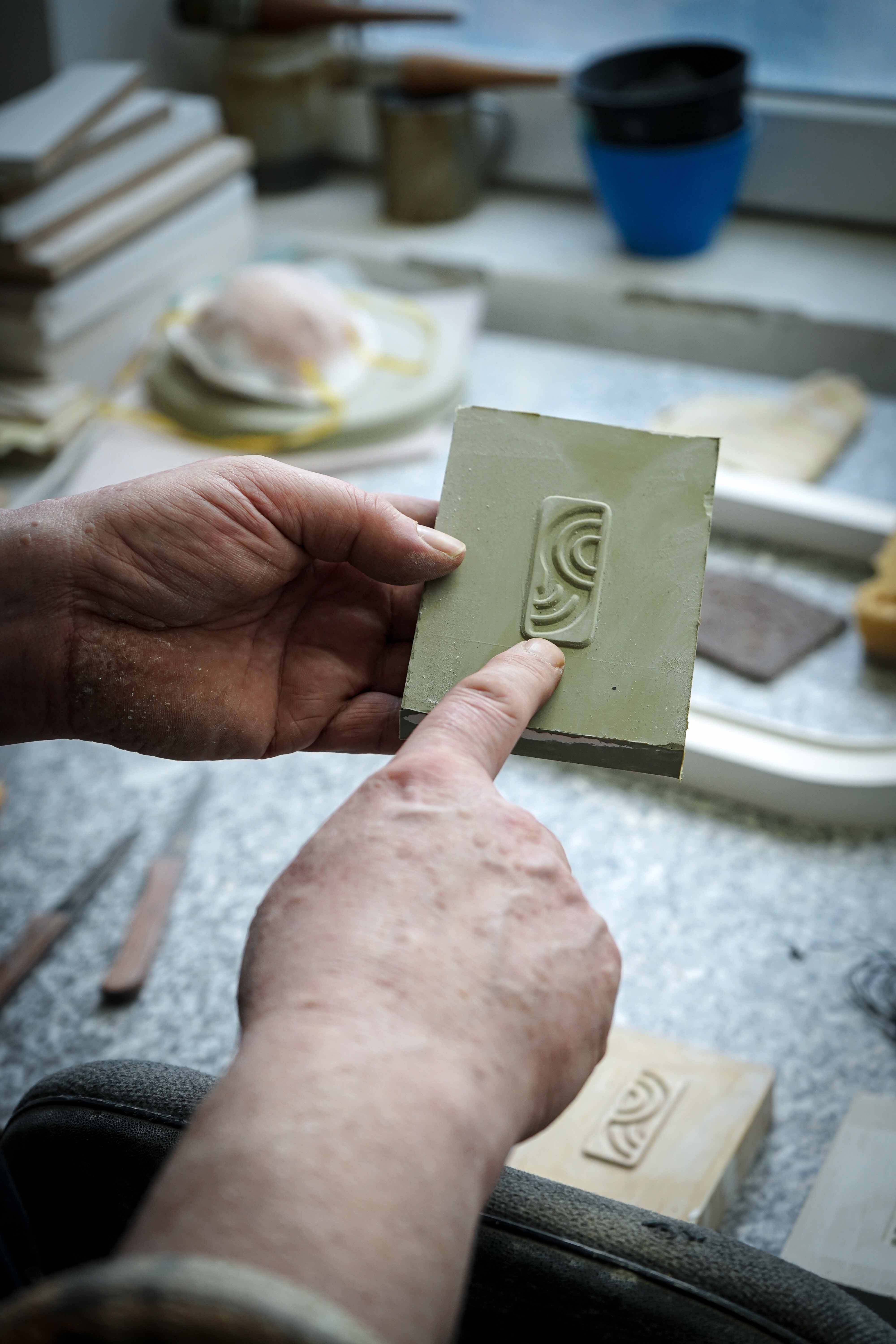 Handarbeit in der myromy Keramik-Manufaktur bei der Ausarbeitung des Logos auf einem Keramikprodukt 